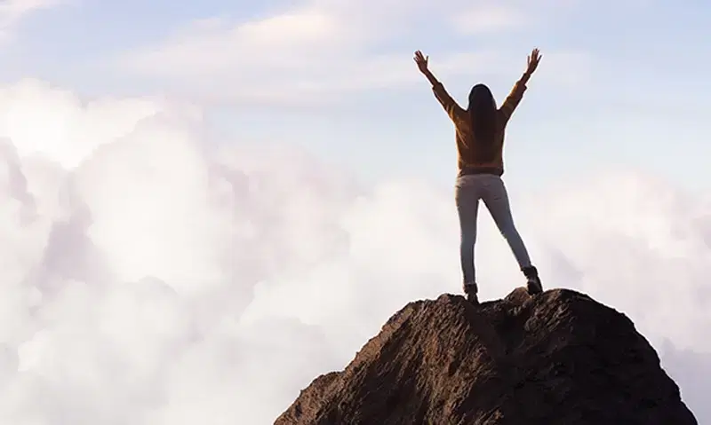 Person standing on top of a mountain